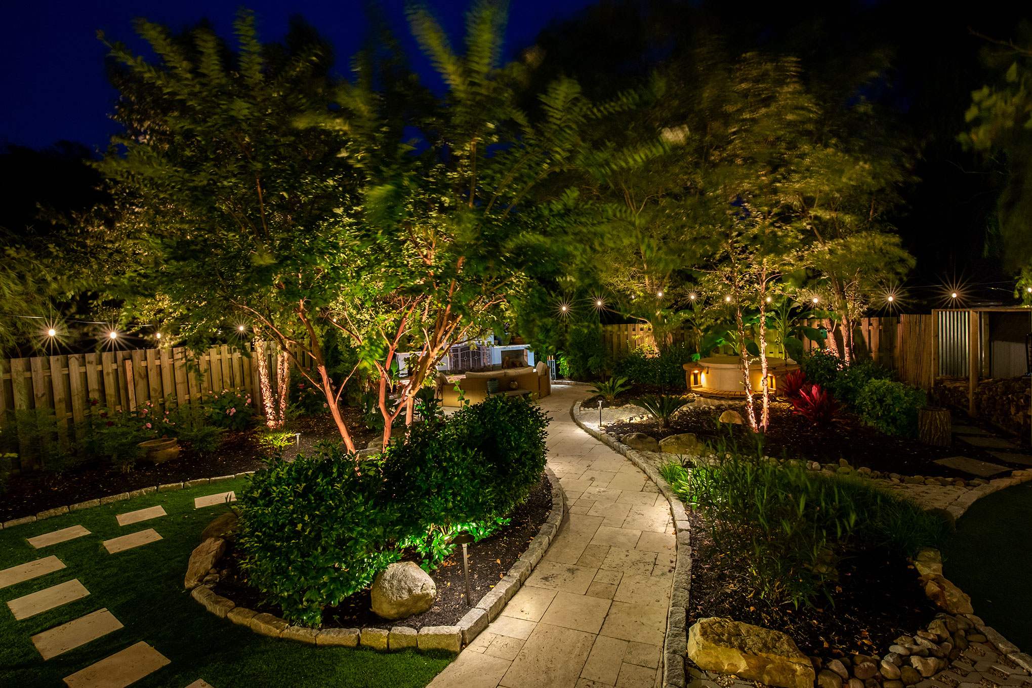 Image of a backyard showcasing lighting, irrigation and hardscaping