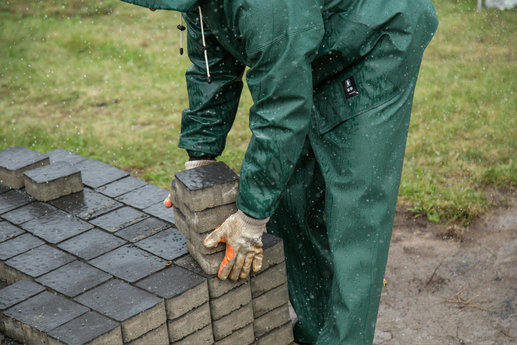 Person bending down and placing pavers into place