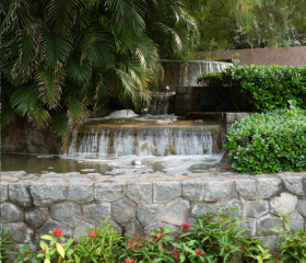 A cascading, man-made waterfall surrounded by trees and foliage